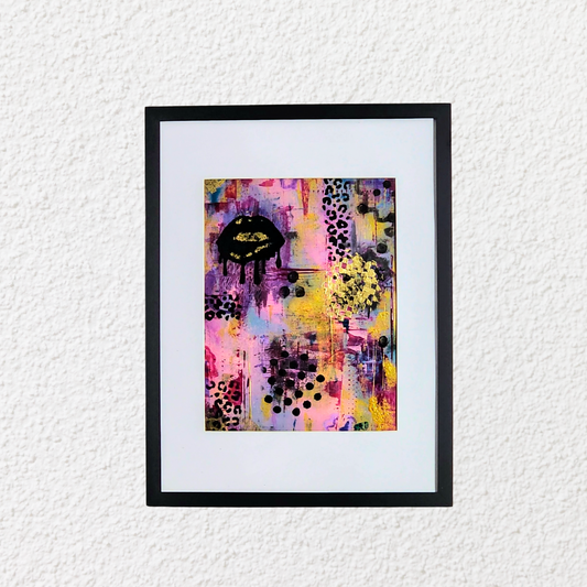 Framed abstract art print with colorful patterns on a white wall