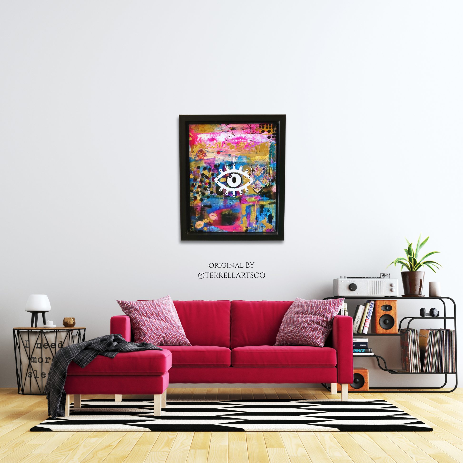 Living room with a red sofa, colorful abstract art, and a shelf with books and plants.